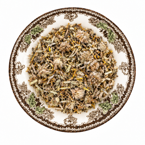 Arnica Flowers dry product on a floral transferware plate against a white background