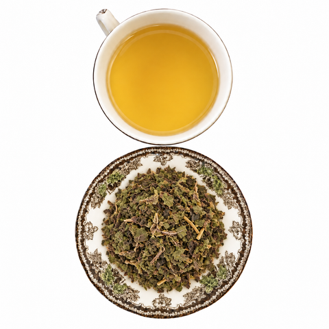 Tulsi (Holy Basil) loose dried herb on a floral transferware plate with a cup of steeped infusion