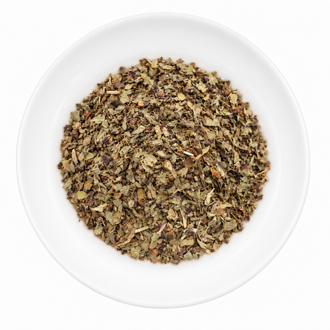 Basil dry spice on a plain white plate against a white background