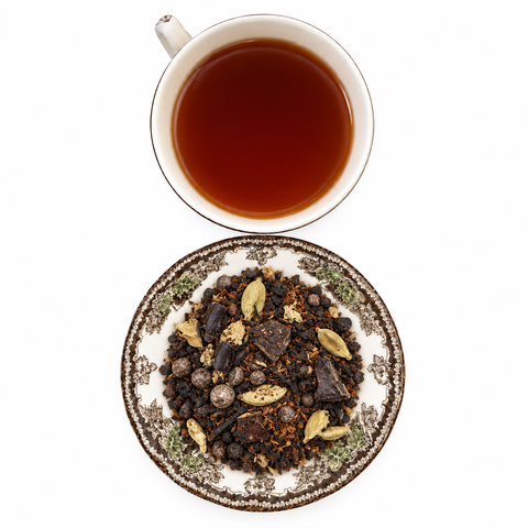 Cacao de la Casa loose tea on a floral plate with a cup of brewed tea
