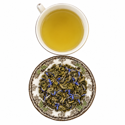 Cream Earl Grey Green loose-leaf tea with brewed tea on a white background
