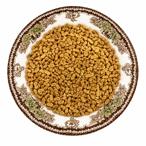 Fenugreek Seed, whole dry product on a floral transferware plate against a white background