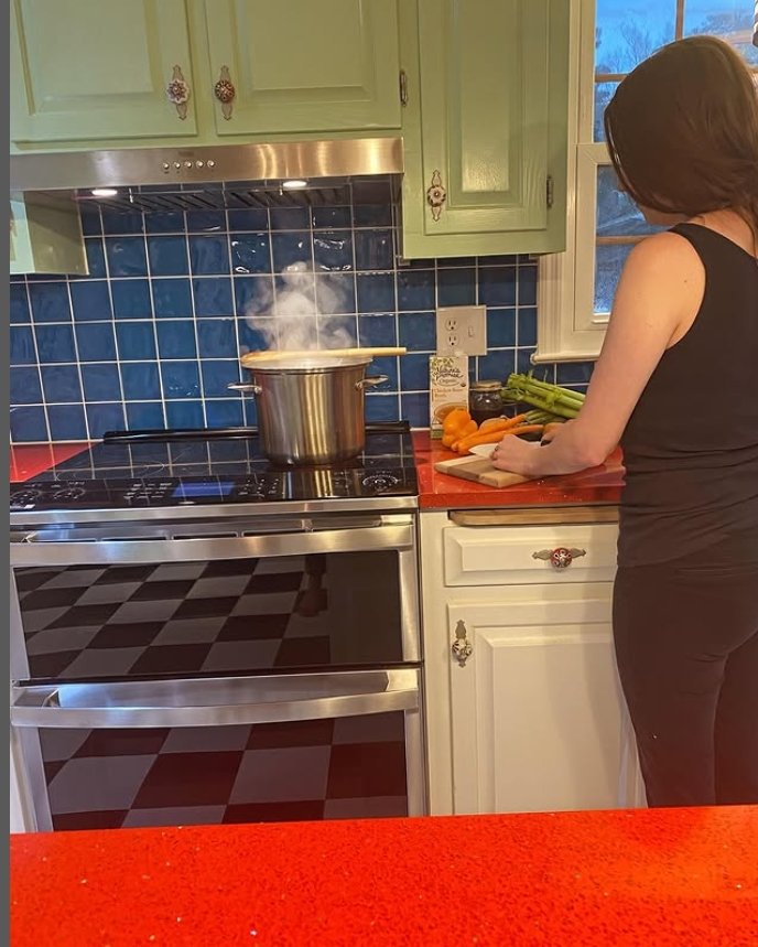 Rachel cooking a recipe in a colorful kitchen.
